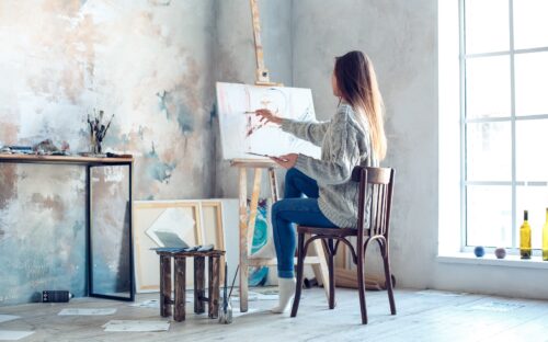 Young,woman,artist,painting,at,home,creative,painting,back,view